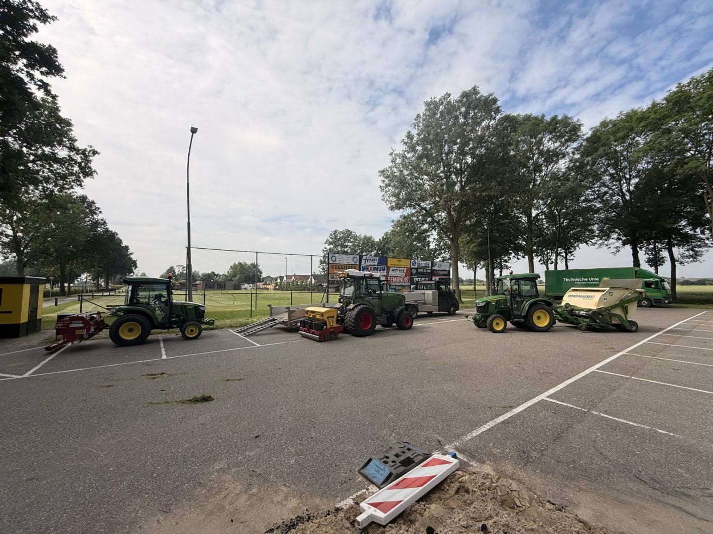 Machines van Grastotaal opgesteld voor sportveldonderhoud bij een voetbalclub